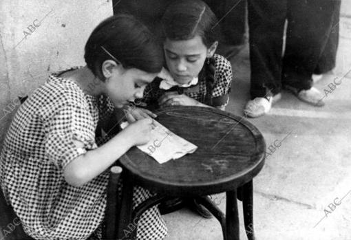 Dos niños escribiendo una carta a su padre, que se encuenta en el frente de la Guerra Civil